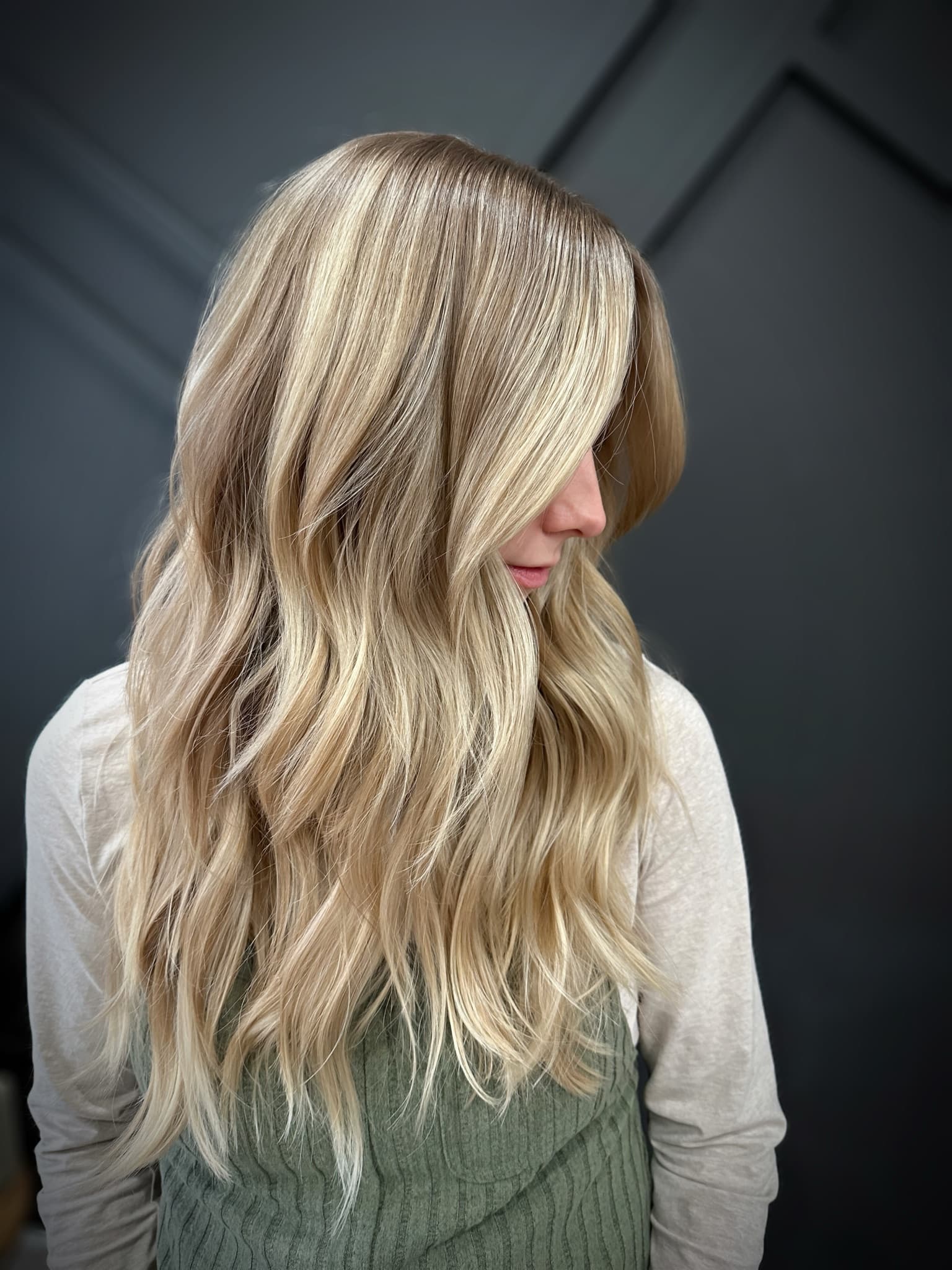 Blonde balayage worn long, the highlights broken up so the grow-out stays soft