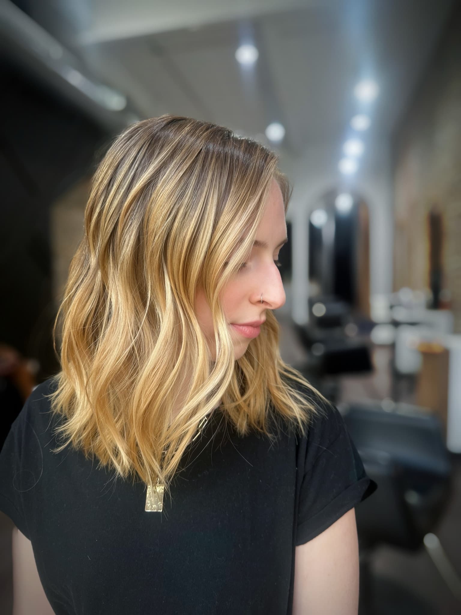 Honey blonde lob styled in loose waves, warm through the mid-lengths