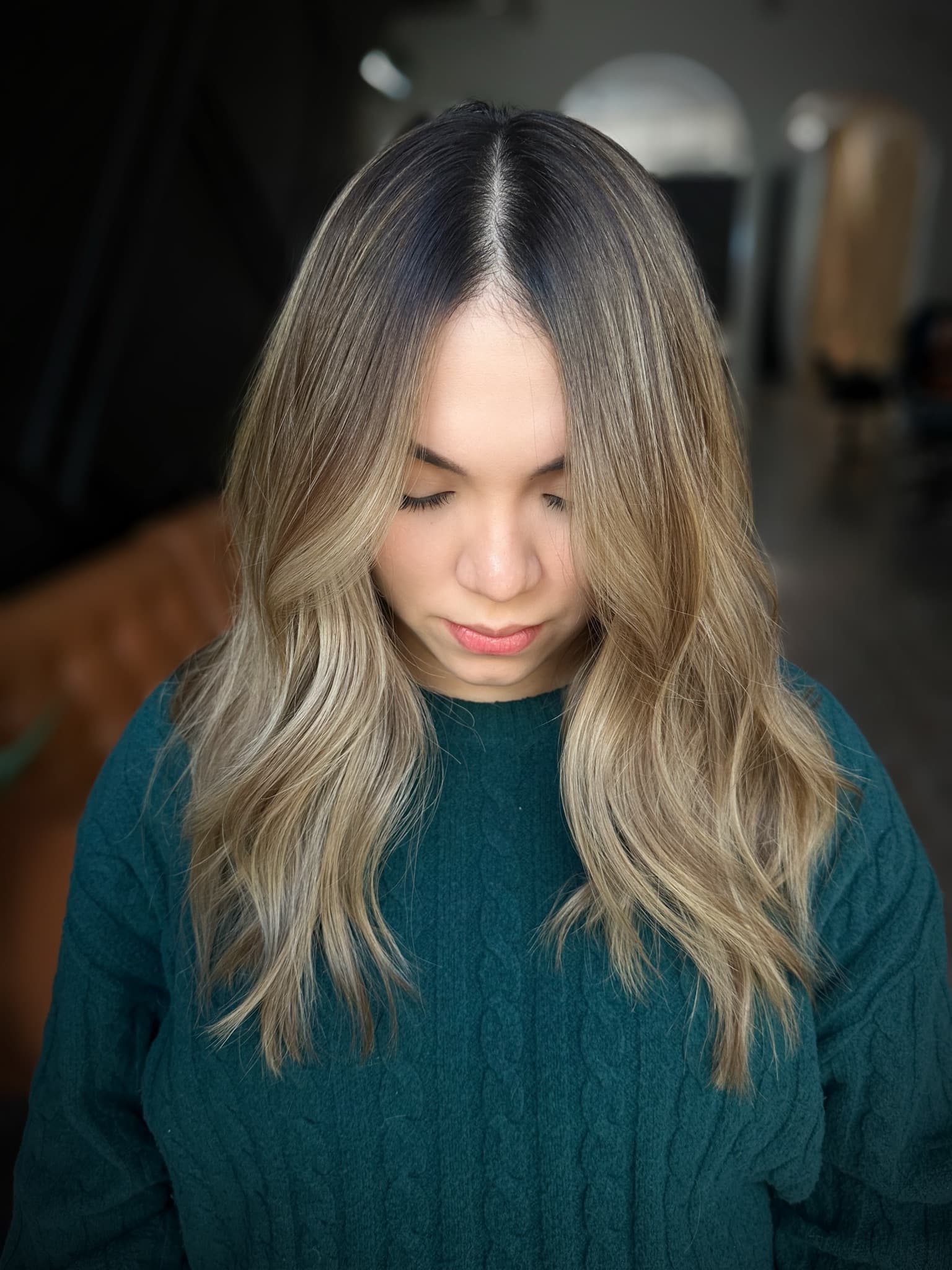 Long blonde balayage layers styled straight with softly waved ends