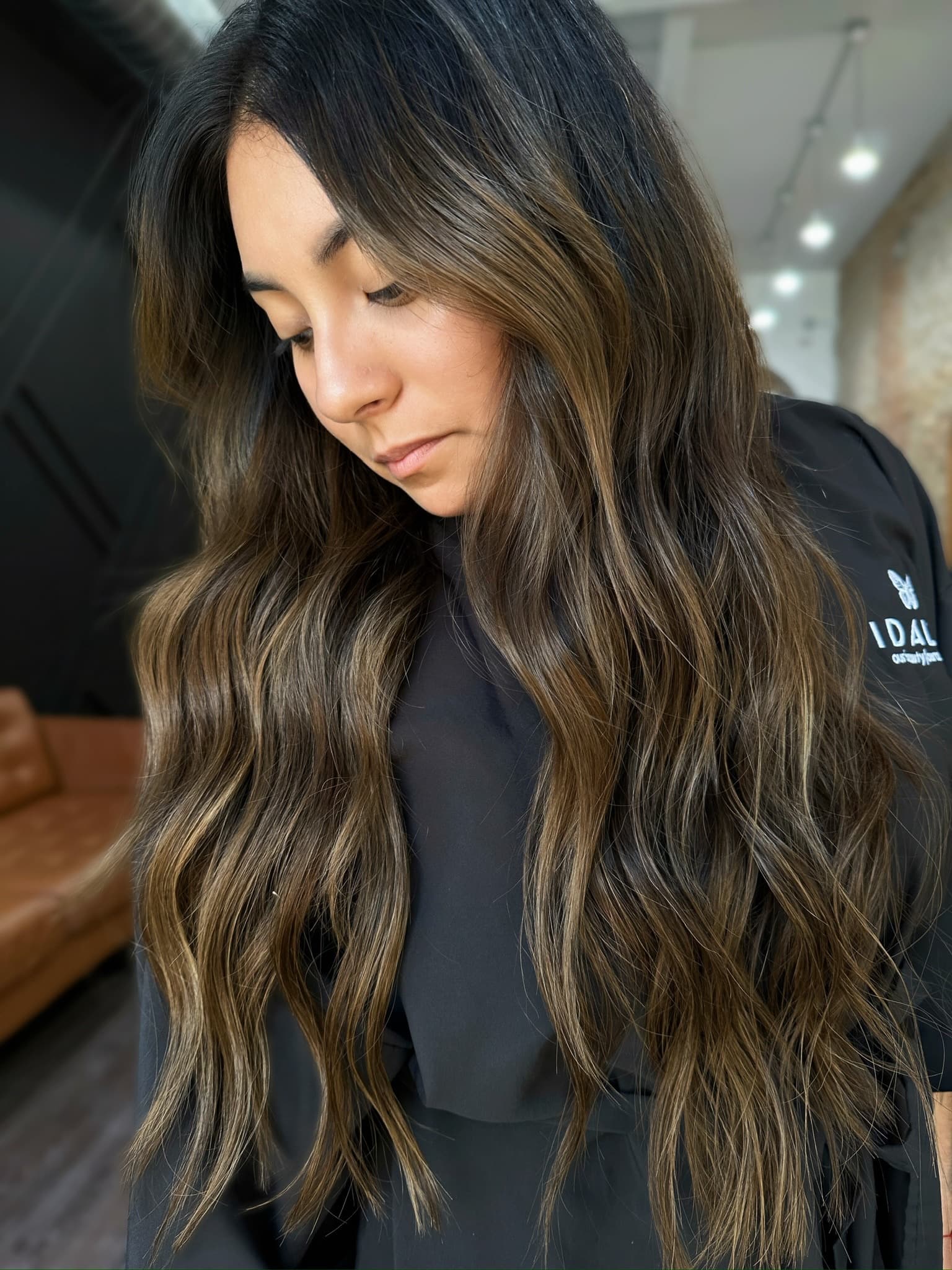 Long, wavy brunette hair with dimensional balayage, extensions blended seamlessly through the length