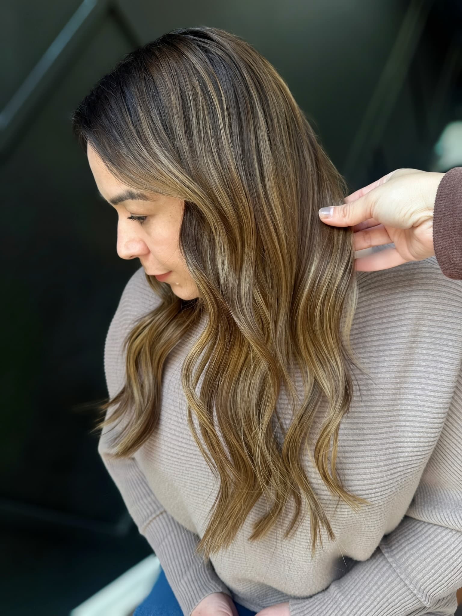 Bronde balayage waves being styled, extensions blended into the natural hair