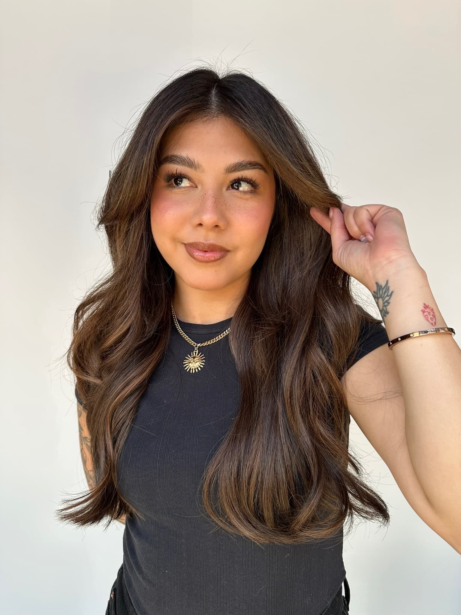 Extension client with long, voluminous brunette waves, relaxed and confident